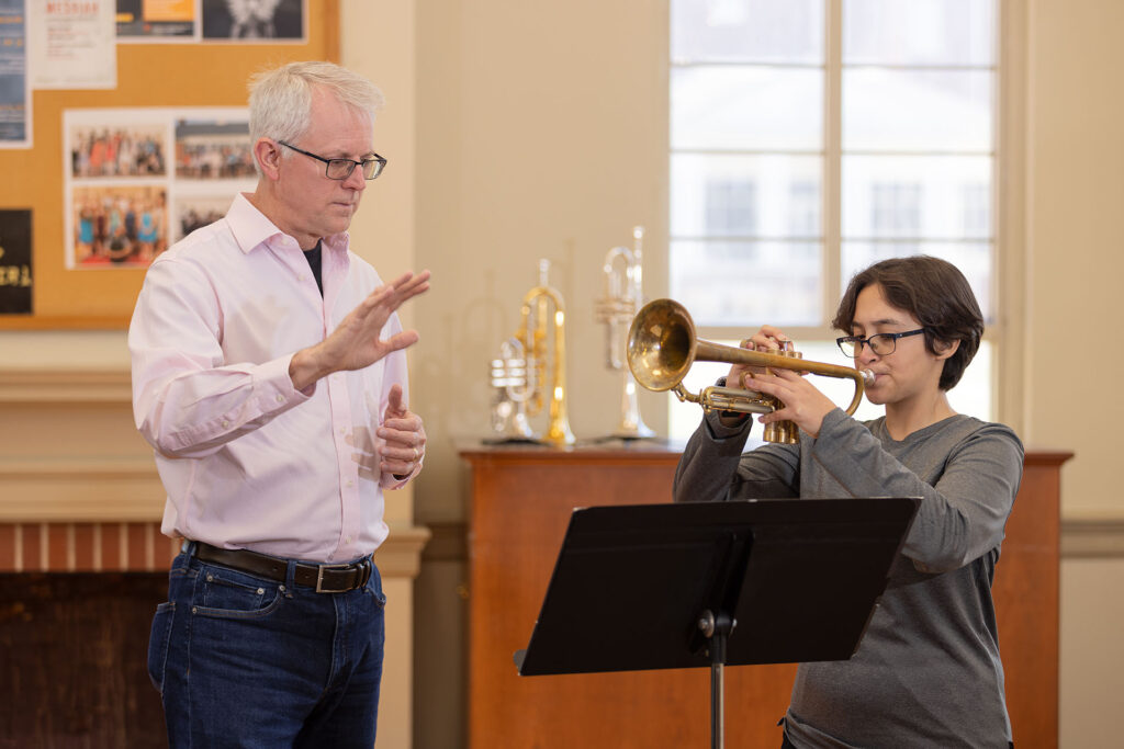 Tim Hudson teaching GWU student the trumpet