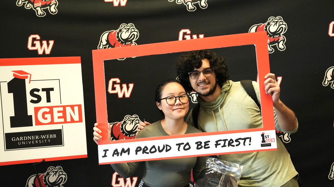 GWU students holding a picture frame that says "I am proud to be first!"