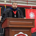 Dr. Wilson Hawkins on stage speaking at fall convocation