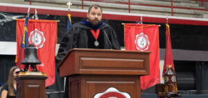 Dr. Wilson Hawkins on stage speaking at fall convocation