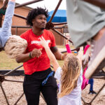 GW football player plays with children on playground