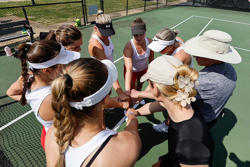 GW Tennis Coach Jim Corn in huddle with women 's tennis players