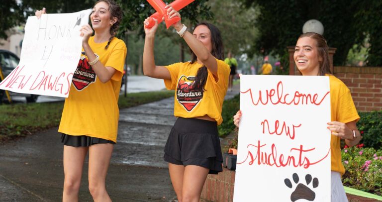Gardner-Webb students holding up welcome signs on move-in day