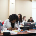 Nursing students learn suturing techniques.