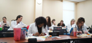 Nursing students learn suturing techniques.