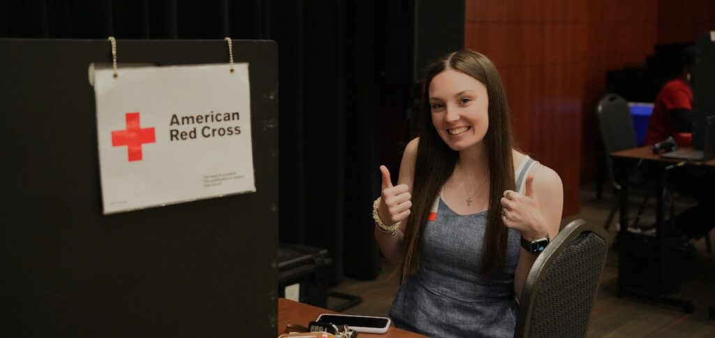 A student gives a thumbs up after giving blood.