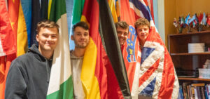 International students pose with flags from their countires