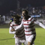 men's soccer players celebrate after a win