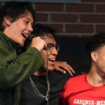 Three male students participate in Open Mic Night
