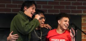 Three male students participate in Open Mic Night