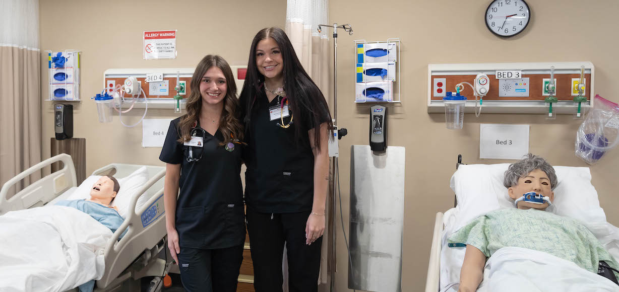 Lauren Padgett and Brianna Payne pose in the nursing simulation lab