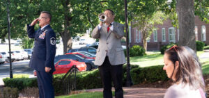 an officer salutes while the trumpeter plays taps