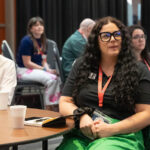 Attendees listen to conference presentations