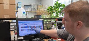 Caleb Hill points to a DNA sequence on a computer screen