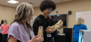 Two students hold skeleton models