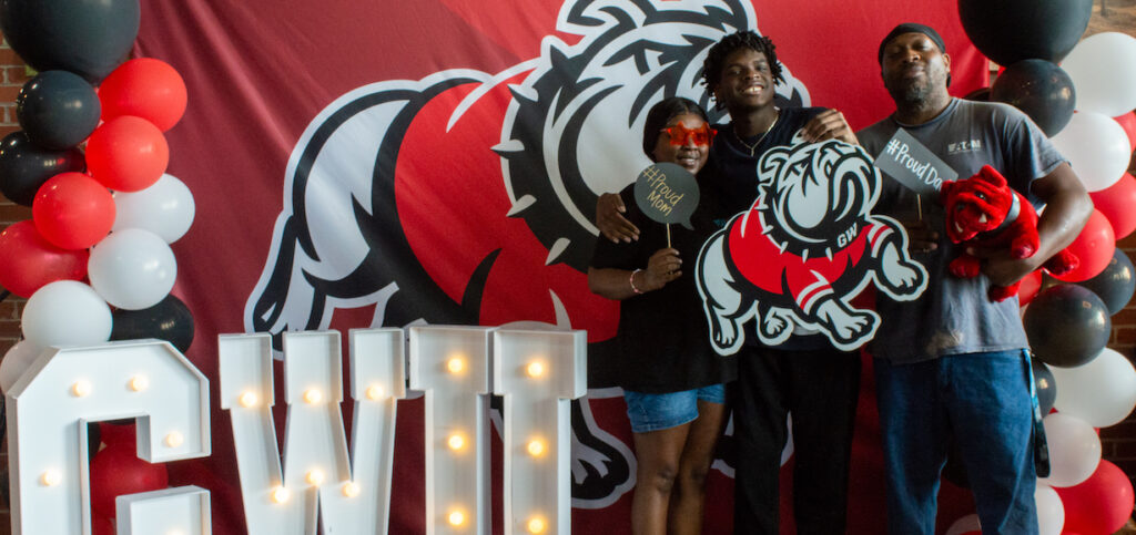 A family poses with Gardner-Webb background and swag
