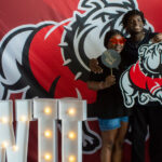 A family poses with Gardner-Webb background and swag