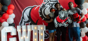 A family poses with Gardner-Webb background and swag