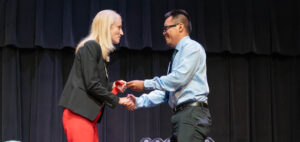 Nicole Waters shakes hand of new visiting instructor Scott Vayakone.