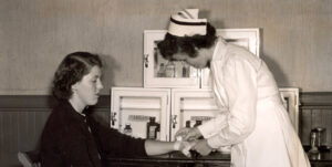 black and white photo of nurse treating person