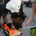 A baby receives candy from a lady