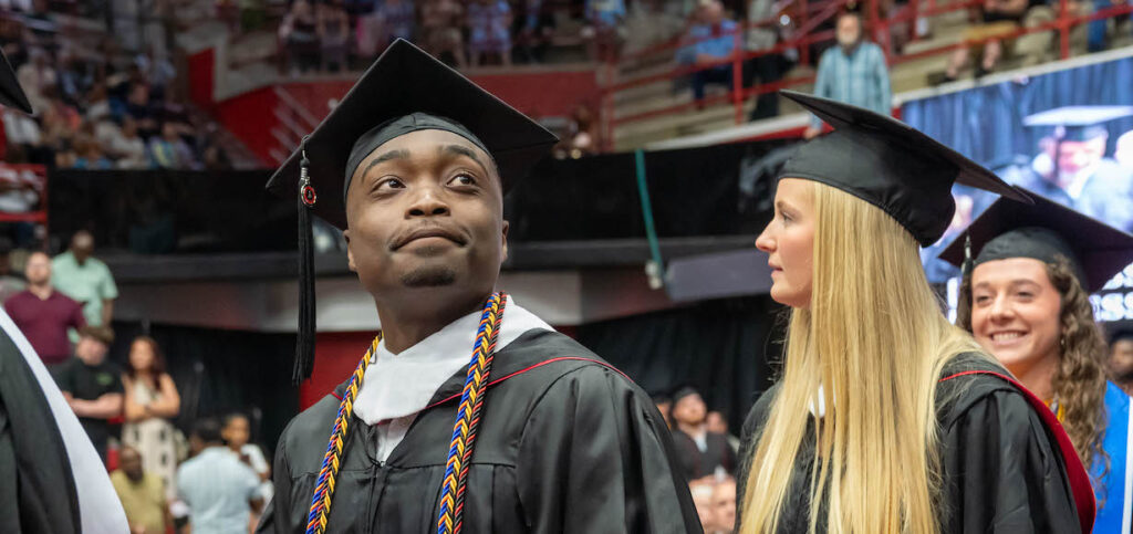A graduate scans the audience during commencement ceremonies commencement