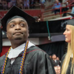 A graduate scans the audience during commencement ceremonies commencement