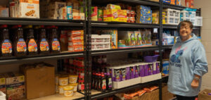 Lou Ann Scates poses in the storage room for the Little Bulldog Backpack Program.