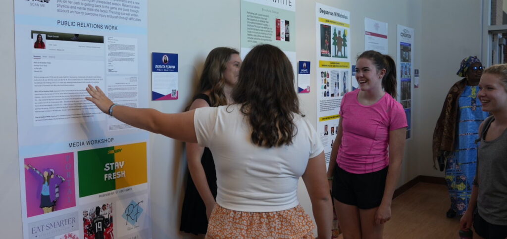 A senior shares about her work during a previous Communication Art Design Senior Portfolio Show.