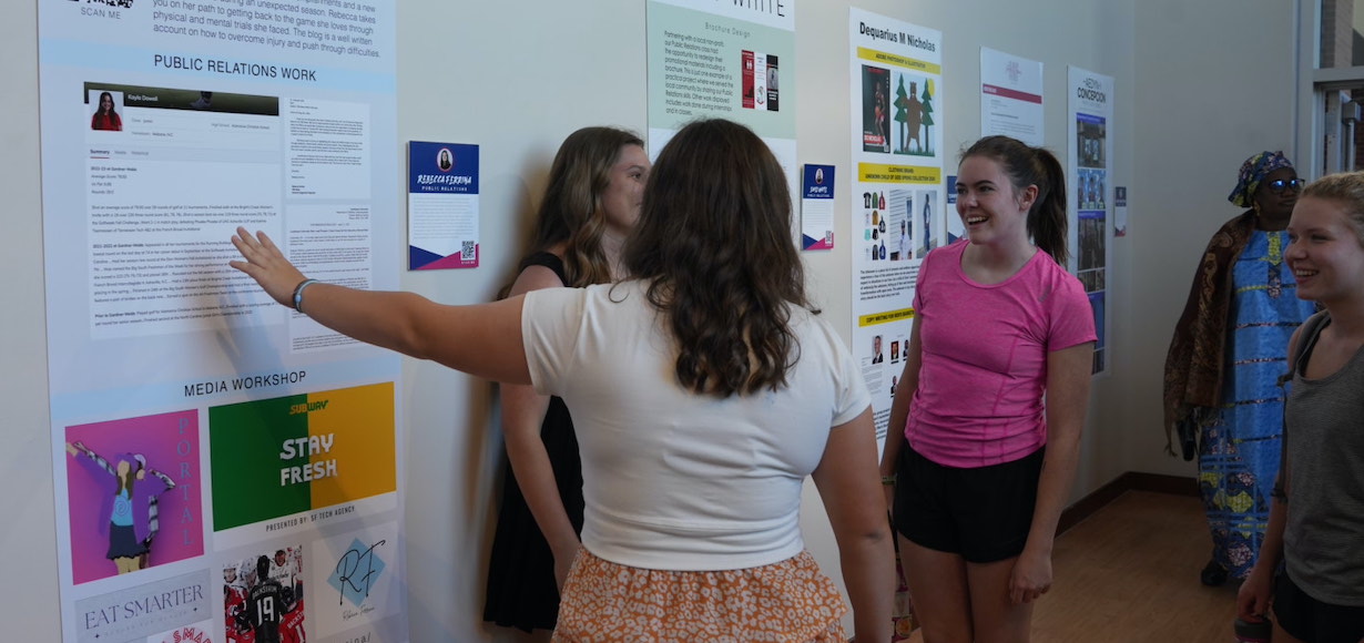 A senior shares about her work during a previous Communication Art Design Senior Portfolio Show.