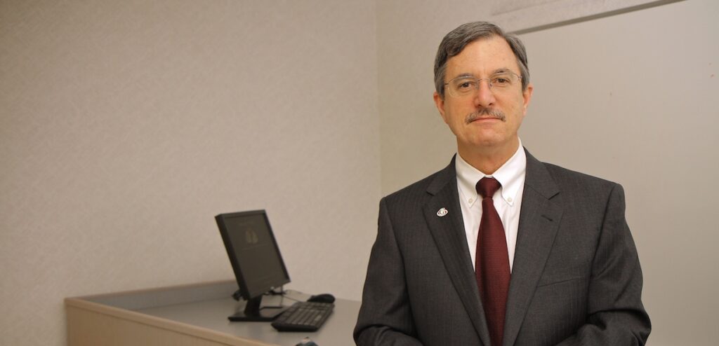 Earl Godfrey poses for a photo while instructing an accounting class.