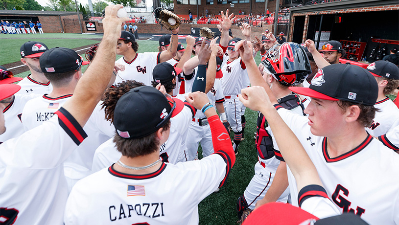 GWU Men's baseball team in a group huddle.