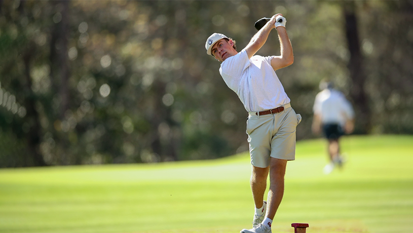 A male student on the golf team hitting a driver.