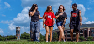 Students walking across campus bell tower tucker