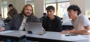 Wade Gross, left, Peer Leader, talks to students in the first-year experience class.